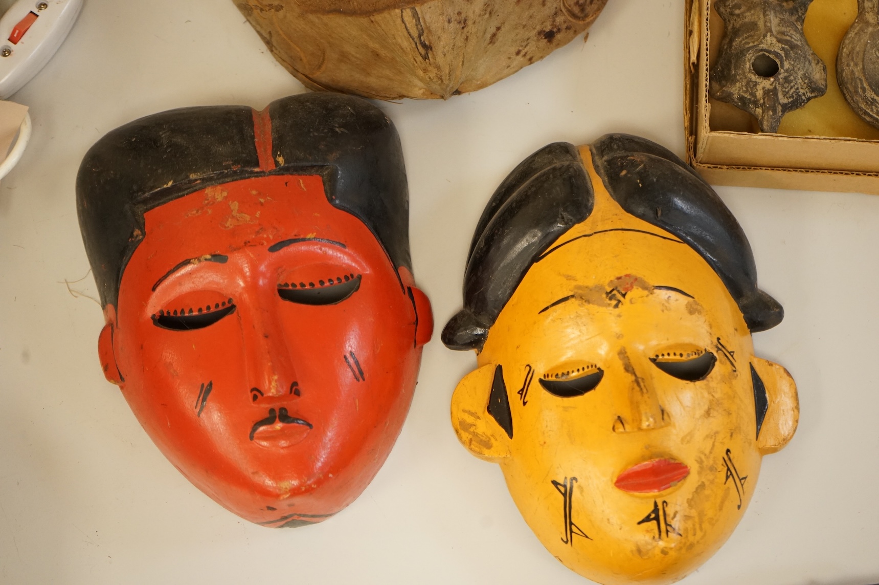 Four Japanese masks, two small oil lamps and a framed batik-16.5high x 19cm wide